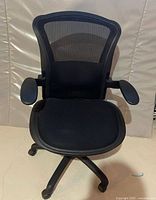 Front view showing mesh back, seat cushion, armrests and base