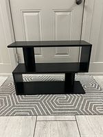 Front view of black two-tier storage shelf