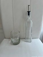 Rocks glass and dressing bottle standing side by side