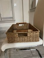 Side view of rectangular wicker basket on chair showing weave and wooden handles