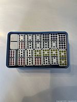 Top view of domino tiles arranged in blue tin