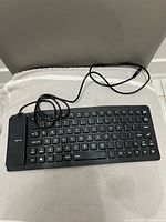 Top view of black flexible silicone keyboard with USB cable attached