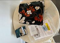 Folded king duvet cover, matching pillowcase, plastic sleeve and paperwork on table