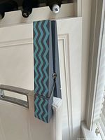 Full view of oversized clothespin clipped to chair showing pattern and scale