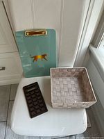 Shows clipboard, calculator and woven basket together