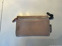 Front view of pink adidas mesh change pouch showing zipper, clip and logo tag