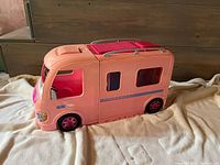 Closed pink Barbie camper van showing exterior and wheels
