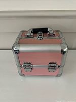 Closed pink train case showing handle and latch