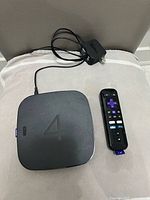 Top view of Roku 4 unit, remote and power adapter