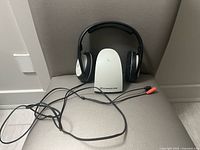 Headphones on charging base with RCA cable visible