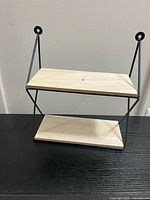 Front view of metal-framed two-tier wall shelf