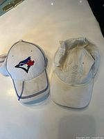 Both baseball caps side by side on surface