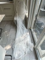 Long white mesh canopy draped on chair, showing netting length