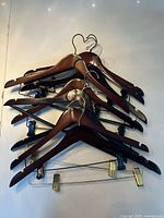 Stacked view of all wooden hangers showing color, metal hooks and clip hanger