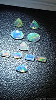 All ten opal gemstones arranged on black surface