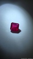 Front view of ruby showing emerald cut and color
