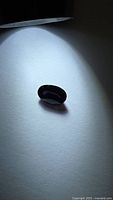Oval deep purple spinel under spotlight