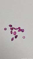 Group of 11 mixed-cut rubies on neutral background