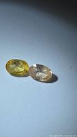 Yellow and peach oval-cut sapphires on white background