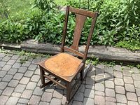 Front angled view of oak rocking chair on patio showing overall form