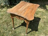 Angled view of table showing top surface, legs, grass background