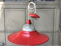 Complete pendant light hanging, showing red shade, glass diffuser, canopy and cord