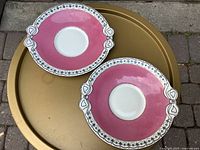 Two pink plates with bow handles overview