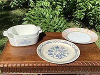 Casserole dishes and two dinner plates displayed together on table