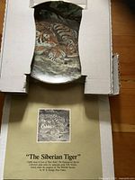 Plate in opened box with certificate visible