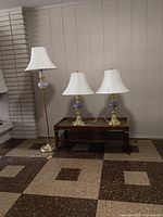 Overall view of three matching brass and glass lamps with shades