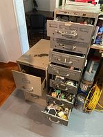 Two beige metal filing cabinets, drawers open showing hardware