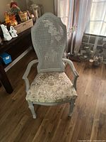 front view of painted wood armchair with cane back and upholstered seat