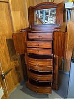 Armoire open showing drawers, side doors and mirror