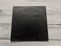 Front cover of AC/DC Back in Black LP showing embossed logo and wear on edges
