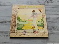 Front cover of Elton John "Goodbye Yellow Brick Road" LP showing artwork and wear