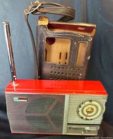 Front view of red Wilco ST-88 transistor radio with telescopic antenna and accompanying brown leather case