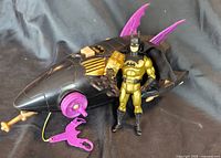 Full view of Batman figure, vehicle, gold weapon and purple hook
