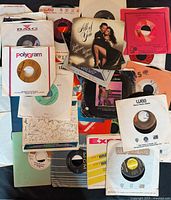 Assortment of seven-inch 45 RPM records in various company sleeves spread out for viewing
