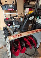 Front and side view of White Outdoor 26-inch 8.5 HP snow blower showing augers, chute, controls and overall wear