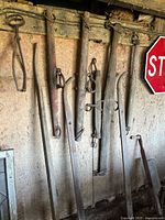 Overall view of six singletrees hanging on barn wall