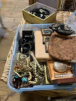 Overview of bin with assorted jewelry, pocket watch and portraits