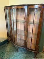 Front view showing bow-front shape, mullioned glass door, curved side panels