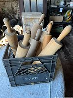 Milk crate holding multiple wooden rolling pins