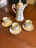 Full view of chocolate pot, cups and saucers