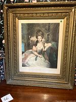 Front view of ornate gold frame holding portrait print