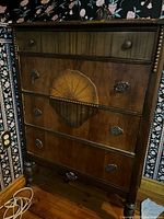Front view showing five drawers, shell motif, beaded columns, hardware
