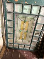 Full view of stained glass window showing central colored design and surrounding clear panes