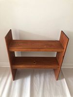 front view of pine bookcase showing two shelves and wear