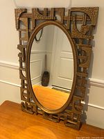 Full view of mirror on tabletop showing entire frame and oval glass