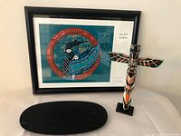 Lot overview showing framed print, cedar totem and wooden tray